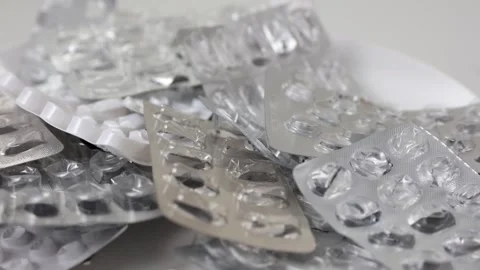 Empty blisters of pills rotating through shot in a seamless loop Stock Footage 280677689