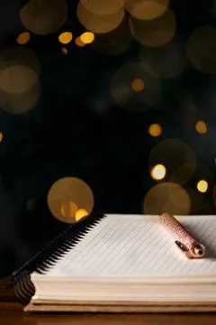 Empty block notes and a pen against magical light bokeh background Stock Photos