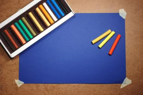Empty blue cardboard background and multicolored pastel - art utensil Foto stock