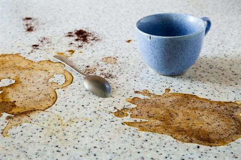 The empty blue cup is on the dirty table and there is a teaspoon. Coffee stai Stock Photos