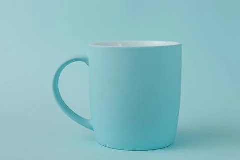 Empty blue cup on same colored blue background. Stock Photos