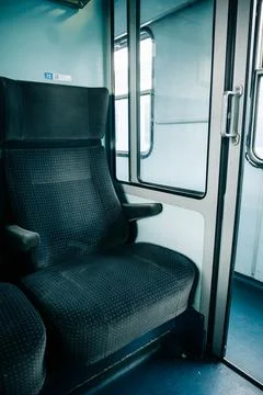 Empty blue fabric seat inside train carriage near window. Quiet modern travel Stock Photos