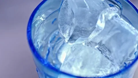 Empty blue glass with cold ice is pouring with smoke on background Stock Footage 139131625