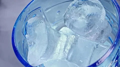 Empty blue glass with cold ice and juice is pouring with smoke on background Stock Footage 139131768