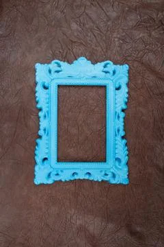 Empty blue painted baroque frame on genuine brown leather pattern, pop art .. Stock Photos
