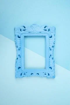 Empty blue painted baroque frame on blue shades color background, pop art s.. Stock Photos
