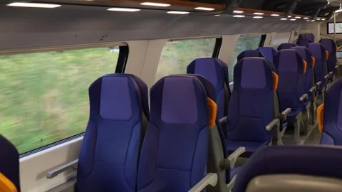 Empty blue passenger seats with yellow handles inside modern train carriage Stock Footage 345446822