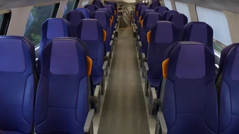 Empty blue passenger seats with yellow handles inside modern train carriage Stock Footage 345446829