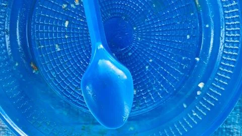 Empty blue plastic bowl with a matching blue plastic spoon Stock Photos