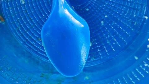 Empty blue plastic spoon resting inside a textured blue bowl Stock Photos
