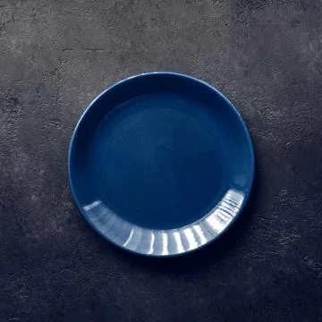 Empty blue plate on black background, vintage toning Stock Photos