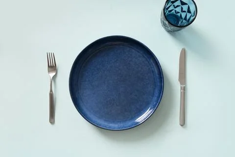 Empty blue plate on blue kitchen background. Stock Photos