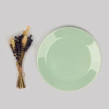 Empty blue plate with bunch of dried herbs on light background Stock Photos