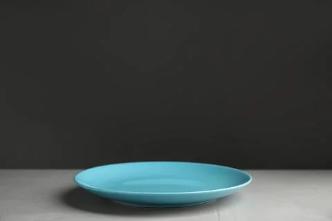 Empty blue plate on light grey table. Space for text Stock Photos