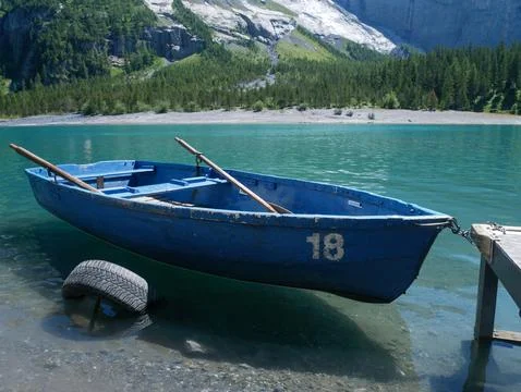 Empty Blue Rowboat Floating on Turquoise Alpine Lake Water, Vacation Rental, Swi Foto stock