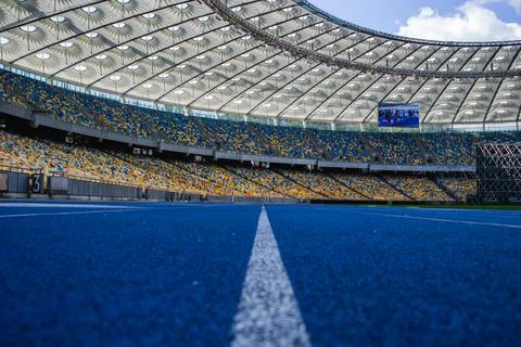 Empty blue running track at the olympic stadium Stock Photos