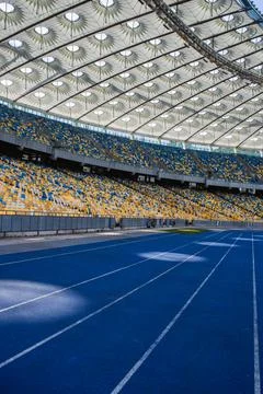 Empty blue running track at the olympic stadium Stock Photos