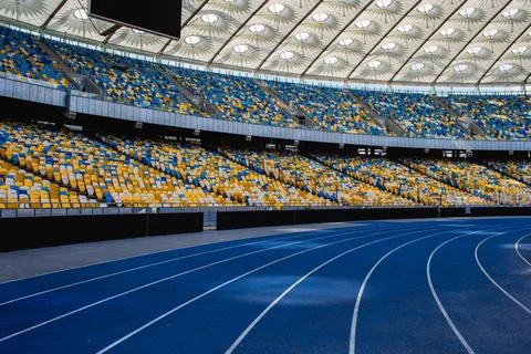 Empty blue running track at the olympic stadium Stock Photos