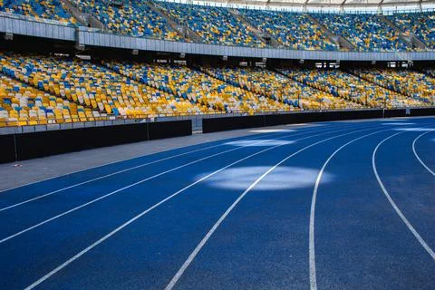 Empty blue running track at the olympic stadium Stock Photos