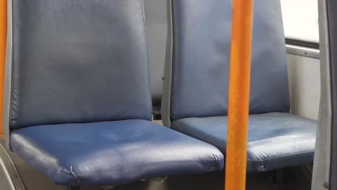 Empty blue seats and orange handrails in public transport in a trolleybus Stock Footage 304274000