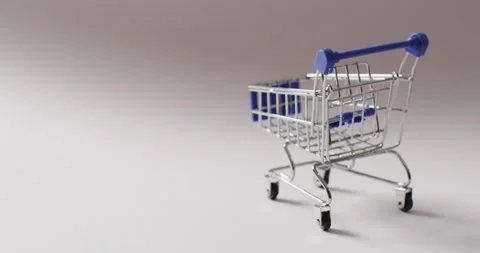 Empty blue shopping trolley on seamless grey background Stock Footage 345799233