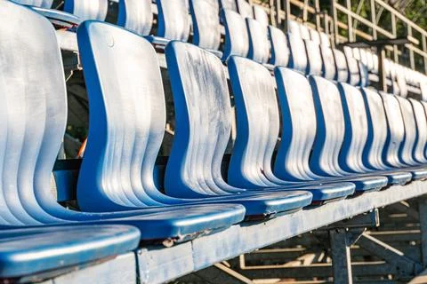 Empty blue stadium seats in a row, ascending order, simple design, no armre.. Stock Photos