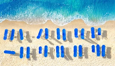 Empty blue sun beds on yellow sand beach, aerial panorama from directly above Foto stock