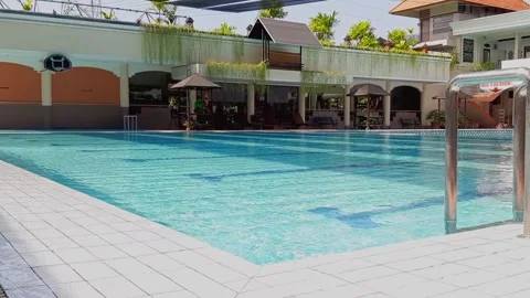 Empty Blue Swimming Pool Corner with Stainless Ladder White Ceramic Edge Morning Stock Footage 316479814
