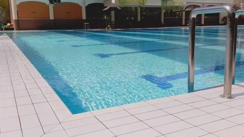 Empty Blue Swimming Pool Corner with Stainless Ladder White Ceramic Edge Morning Stock Footage 316527959