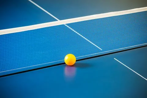 Empty blue table with a net and a yellow ball Stock Photos