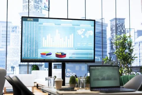 Empty boardroom setup with a computer displaying financial data Foto stock