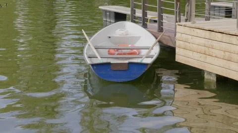 The empty boat bobs on the waves of heavy seas. Stock Photos