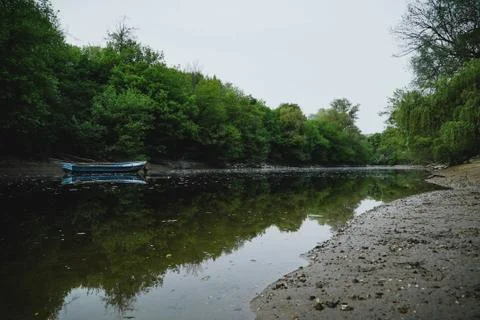 Empty boat in the middle of a river Stock Photos