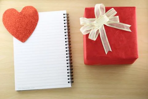 Empty Book and red gift box on the wooden floor. Stock Photos
