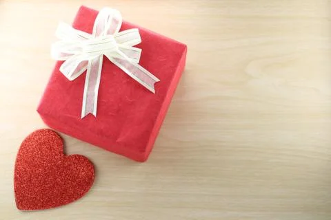 Empty Book and red gift box place near heart shape on the wooden floor. Stock Photos