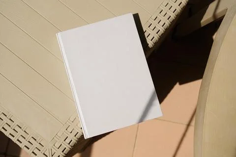 Empty book mockup on plastic table tile floor in the room, shadow overlay Stock Photos
