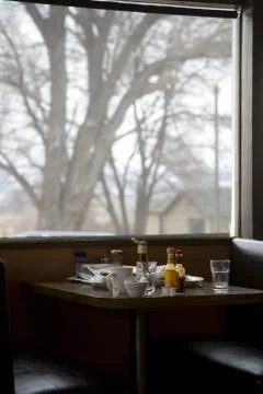 Empty booth at diner with large window and tree Foto stock
