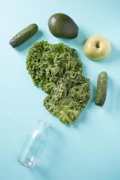Empty bottle and green vegetables for smoothie. Top view. Stock Photos