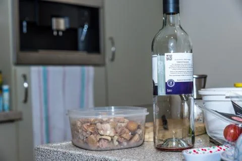 Empty bottle of red non alcoholic wine next to tray with cooked chestnuts on Stock-Fotos