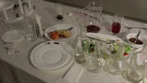 Empty bottles , decanters and plates on the table after the Banquet Stock Footage 106558936