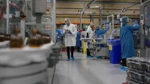 Empty bottles moving on conveyor belt and worker operating control board Stock Footage 107983122