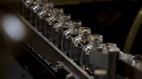 Empty bottles moving down a Factory Machine in a Industrial Warehouse Stock Footage 129929307