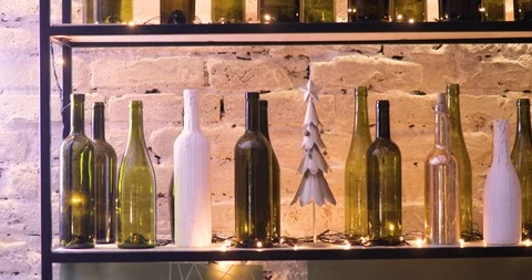 Empty bottles of wine on shelf with blinking garland in Christmas time. Stock Footage 120133556
