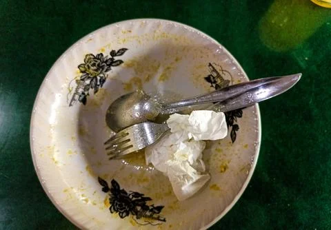An Empty Bowl With Fork, Spoon, and dirty Tissue Foto stock