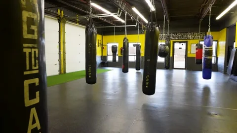 Empty Boxing Gym Interior with Hanging Heavy Bags Under Industrial Lighting Stock Footage 330576545