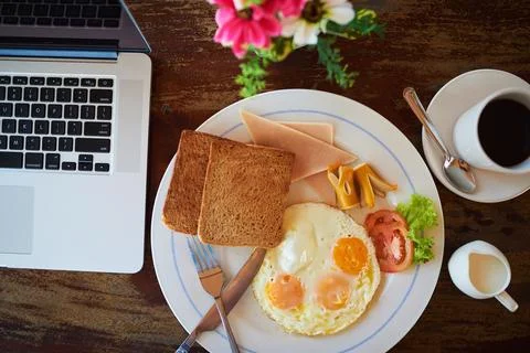 Empty, breakfast and laptop on table in home with coffee for nutrition, protein Stock-Fotos