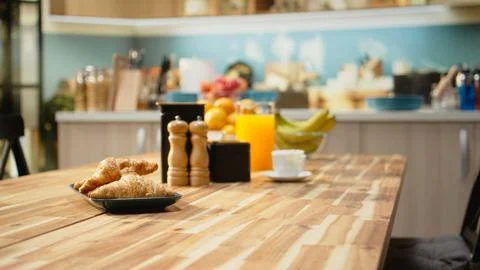 Empty breakfast table in a modern kitchen featuring croissants on plate Stock Photos