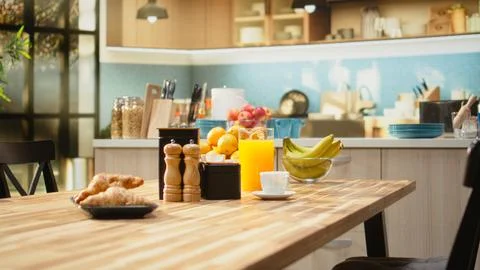 Empty breakfast table in a modern kitchen featuring croissants on plate Stock Photos