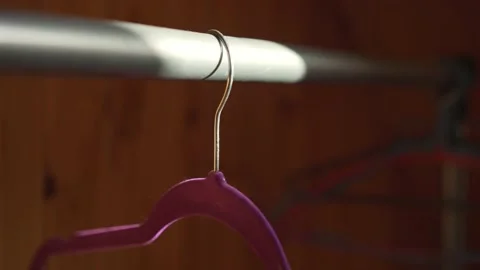 Empty bright hanger for coat and dress hanging on rack in closet Stock Footage 154849503