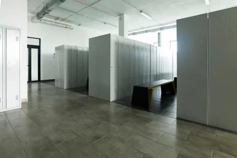 Empty bright locker room and metal bench Stock Photos